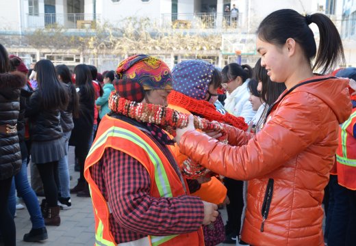 织女们为环卫工人系上亲手编织的爱心围巾